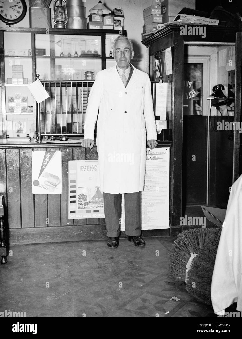 Herr George May, Postmeister von Downe, Kent, an seinem Postschalter und Telefonkasten. Oktober 1937. Stockfoto