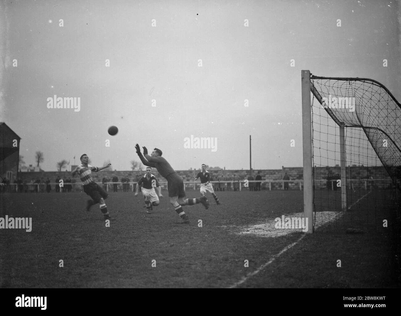 London Paper Mills vs. Dartford Reserves - Kent League - London Paper Mills Torwart Gordon Bennett stürzt sich zum Ball - 26/12/37 einer der Torhüter kommt heraus, um einen Luftball zu sammeln. 1937 Stockfoto