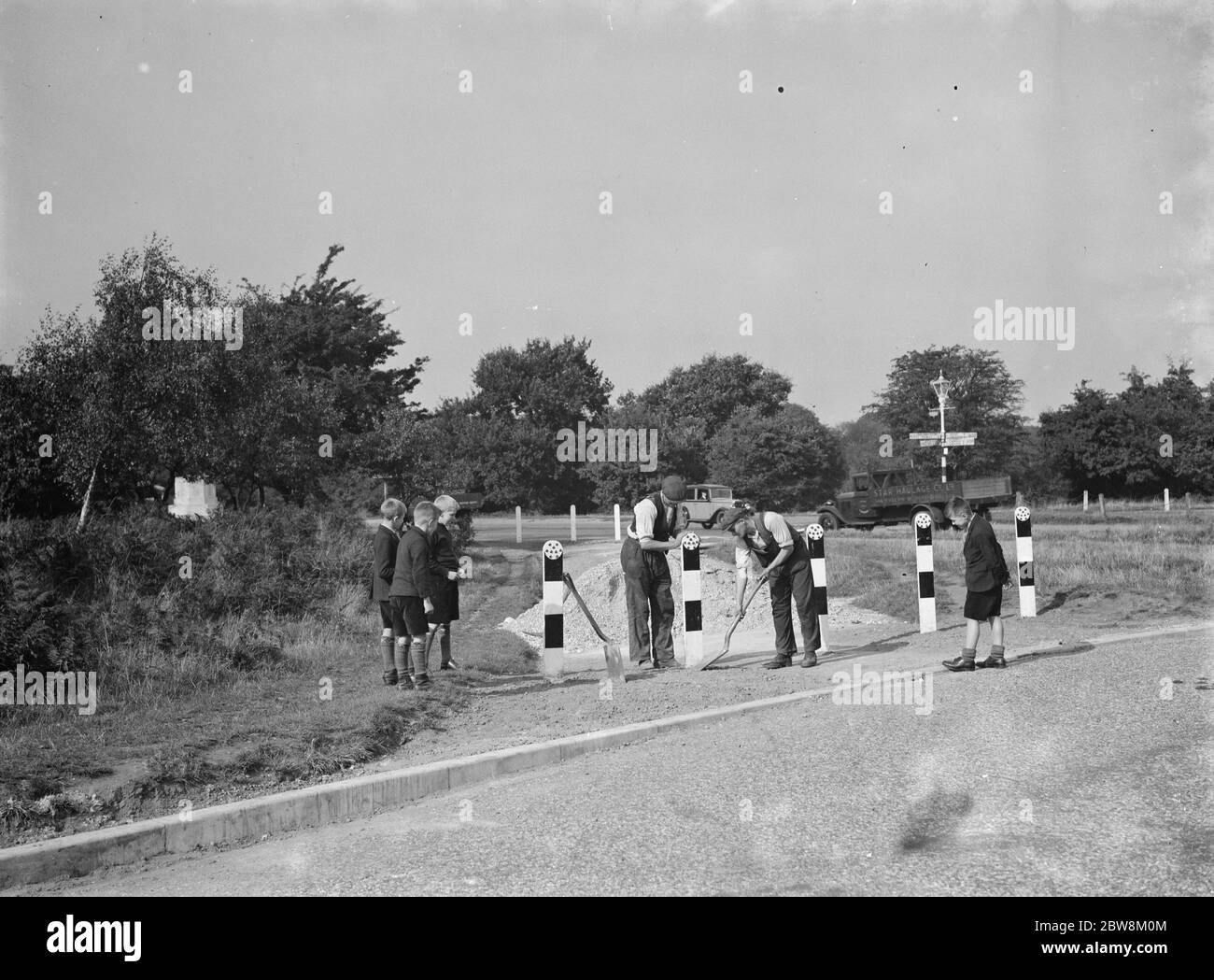 Arbeiter an den Chislehurst Cross Straßen werden von Kindern beobachtet. 1937 . Stockfoto