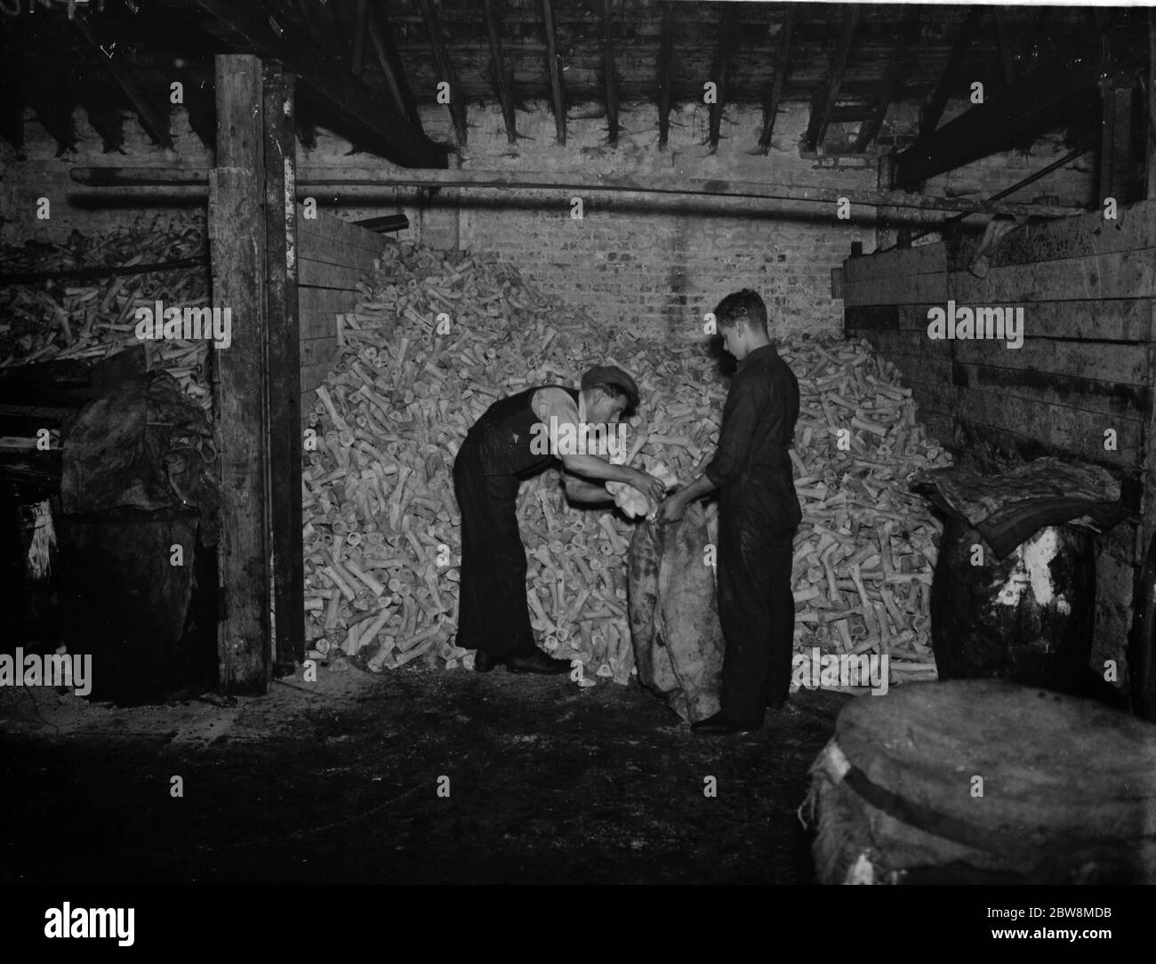 Männer füllen Säcke durch einen Haufen von Knochen bei Curley ' s Verbrennungsanlagen, Stratford. Curley ' s Bone Factory 5. Oktober 1937 Stockfoto
