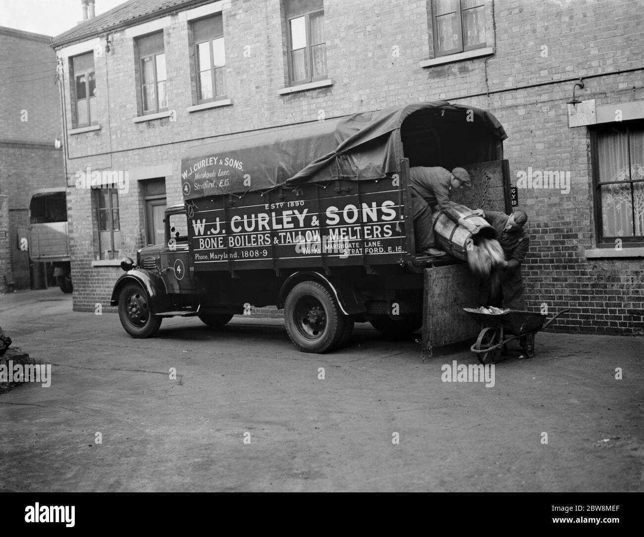 Männer, die Knochen und Tierabfälle von einem WJ Curley ' s LKW in Stratford, East London entladen. Oktober 1937 Stockfoto