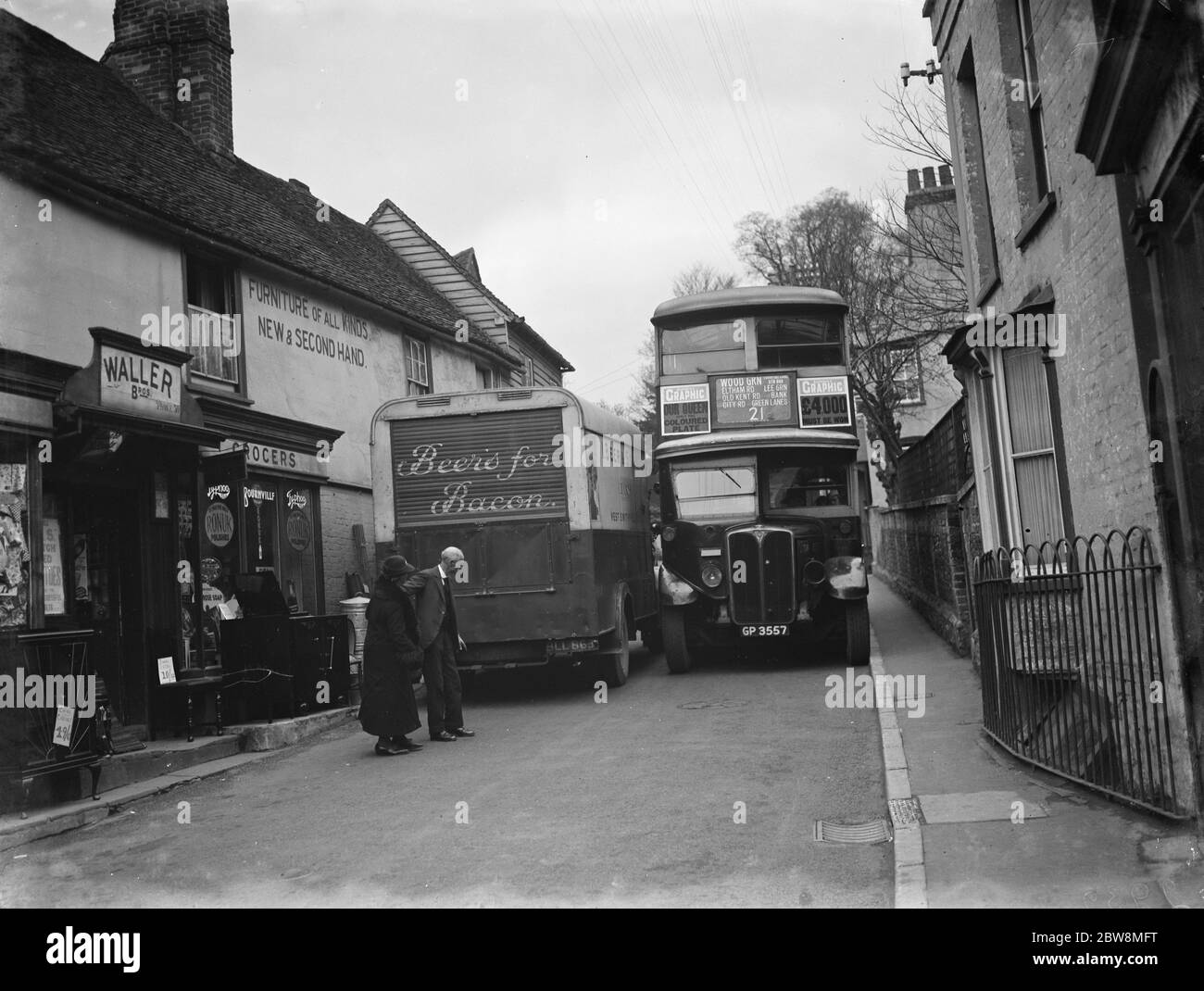 Ein Metzgerbus und der Bus der Linie 21 drängen sich in den engen Farningham Straßen aneinander vorbei. 1936 . Stockfoto