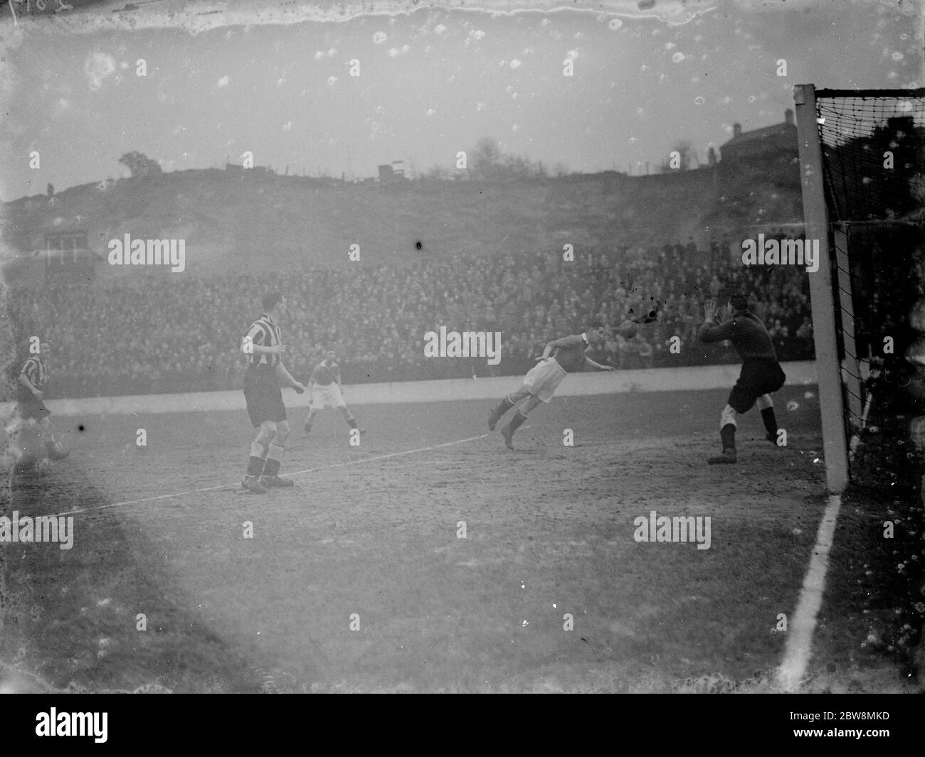 Charlton Athletic Fußballverein gegen Newcastle United Football Club . Der Torwart macht sich bereit, einen Header zu speichern. 1936 Stockfoto