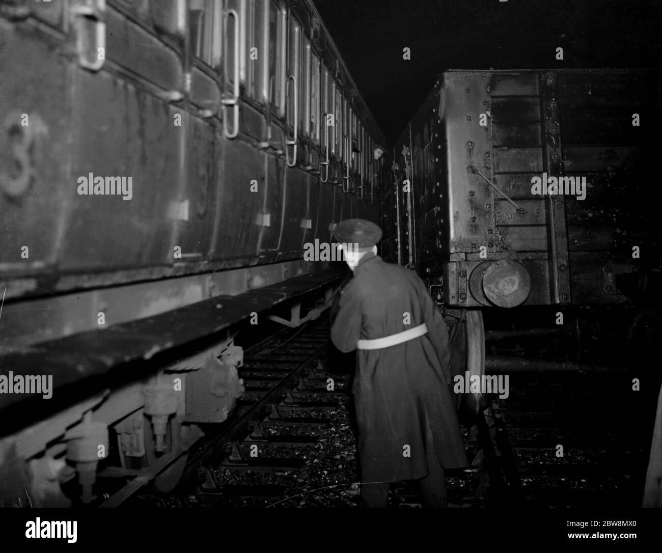Ein Eisenbahner überprüft Zugwaggons nach einem Zugunglück in Mottingham. Ein Zugwagen kann gegen einen Fahrgastwagen liegen sehen, der die Schienen verlassen hat. 23 Oktober 1937 . Stockfoto