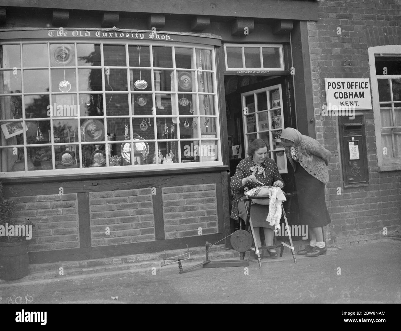 Das Cobham Postamt Shop . Eine Dame sitzt aus der Front machen Spitze. Juli 1938 Stockfoto