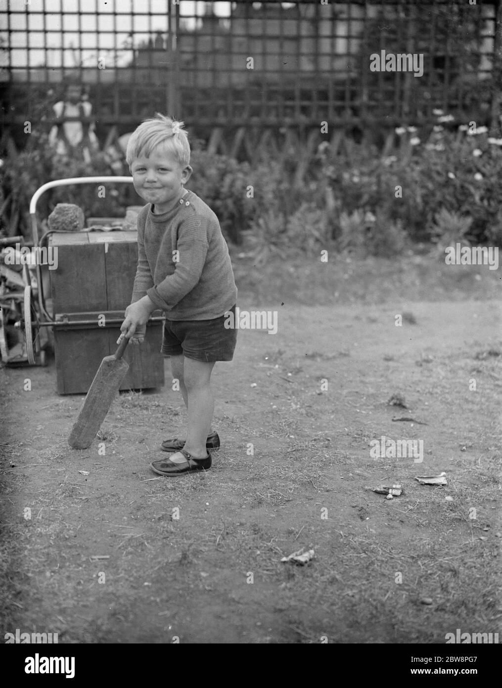 Brian Griffiths posiert mit einer Miniatur-Cricket-Fledermaus. 1938 Stockfoto