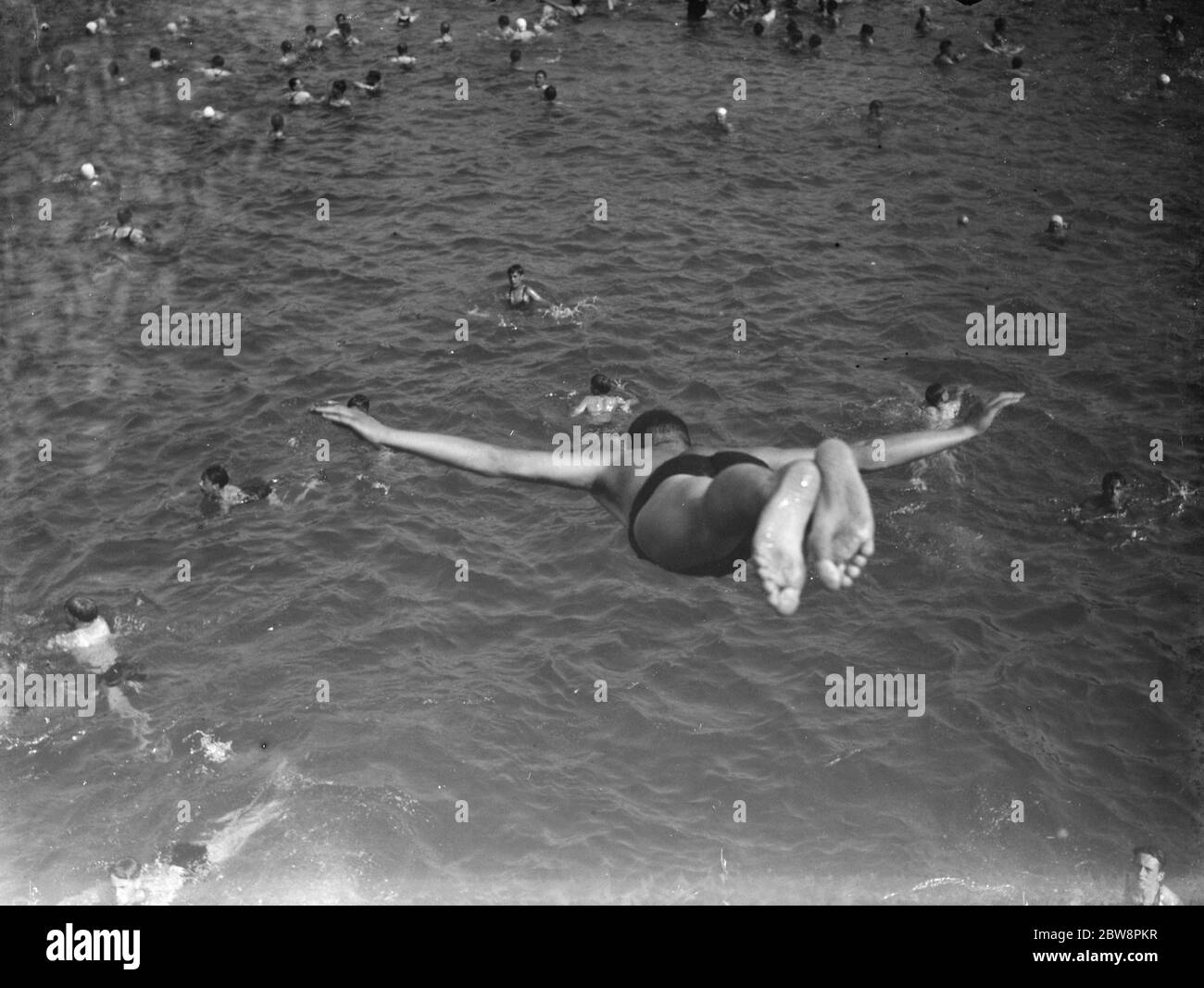 Ein vollgepacktes Bexleyheath-Schwimmbad. Die Baderschwalbe taucht vom Sprungbrett aus. 1938 Stockfoto