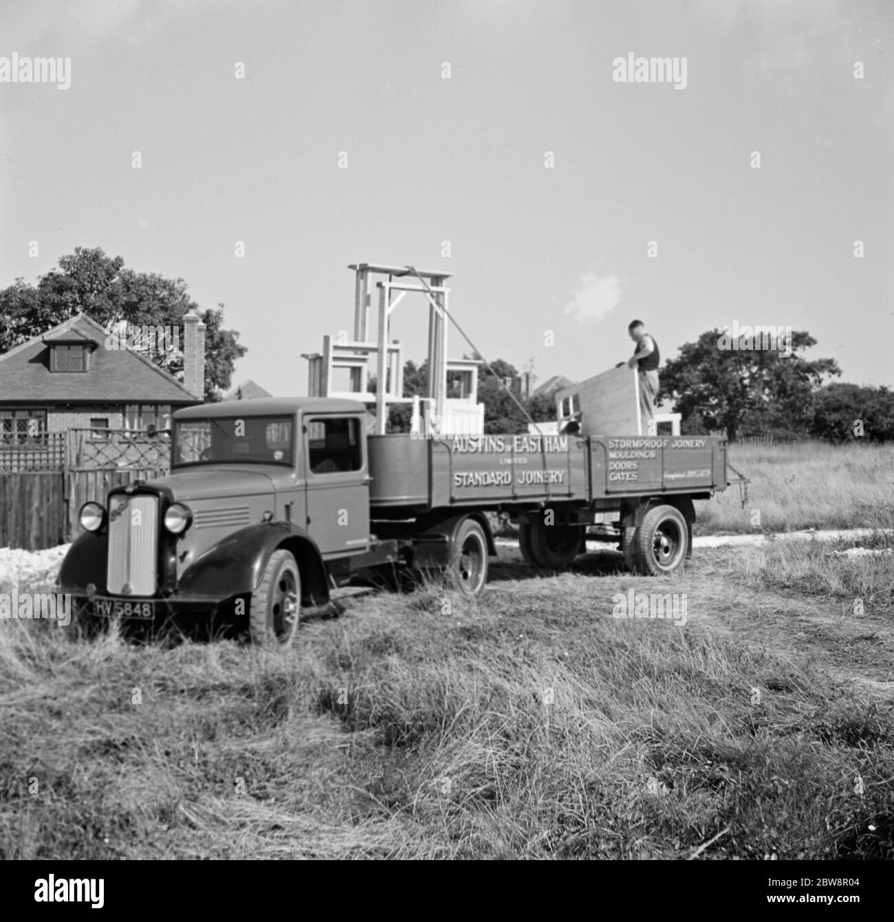 Ein bedford LKW von "Austin und Eastham Standar Joinery", kommt an einem Job mit einem Anhänger voller Holzrahmen. 1936 . Stockfoto