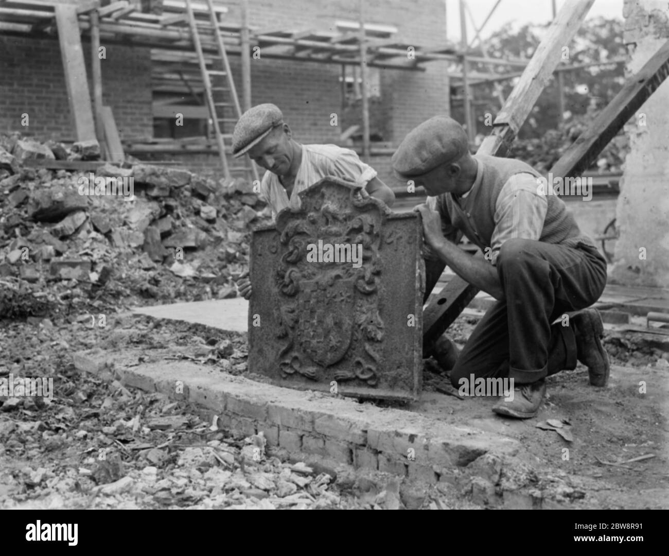 Arbeiter entdecken ein geheimnisvolles Wappen während der Arbeit auf einer Baustelle. September 1936 Stockfoto