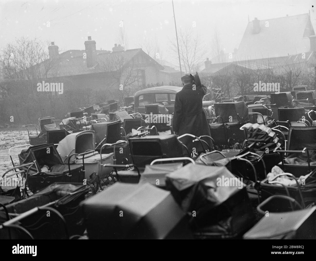 Ein Fahrer kratzt sich am Kopf, als er erkennt, dass sein Auto von Kinderwagen eingekaut ist. 18. Januar 1936 Stockfoto