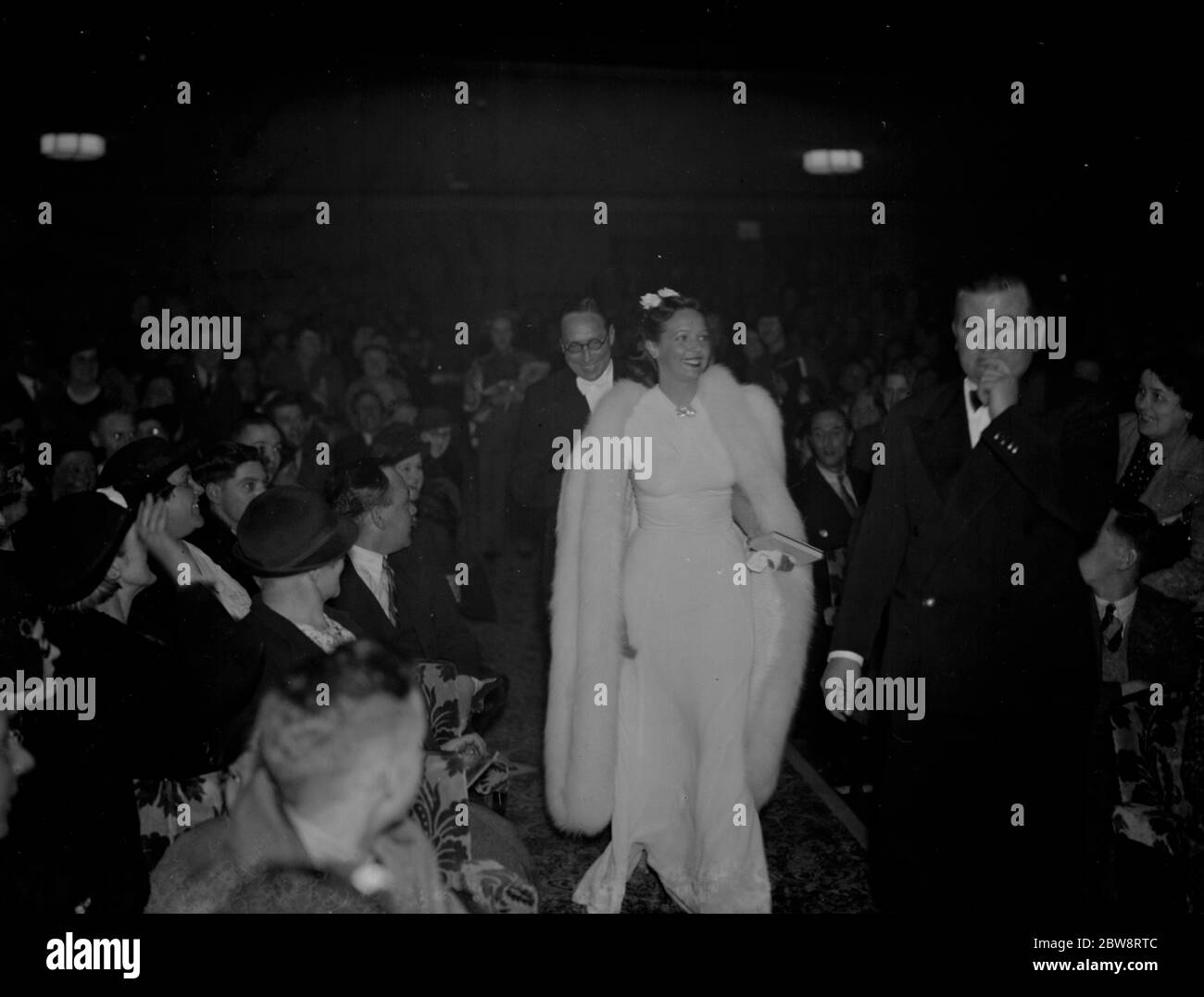 Prominente, Jessie Matthews mit ihrem Mann, Sonnie Hale, gehen durch das Publikum, während sie das neue Granada-Kino in Welling in Kent eröffnen. 1938 Stockfoto