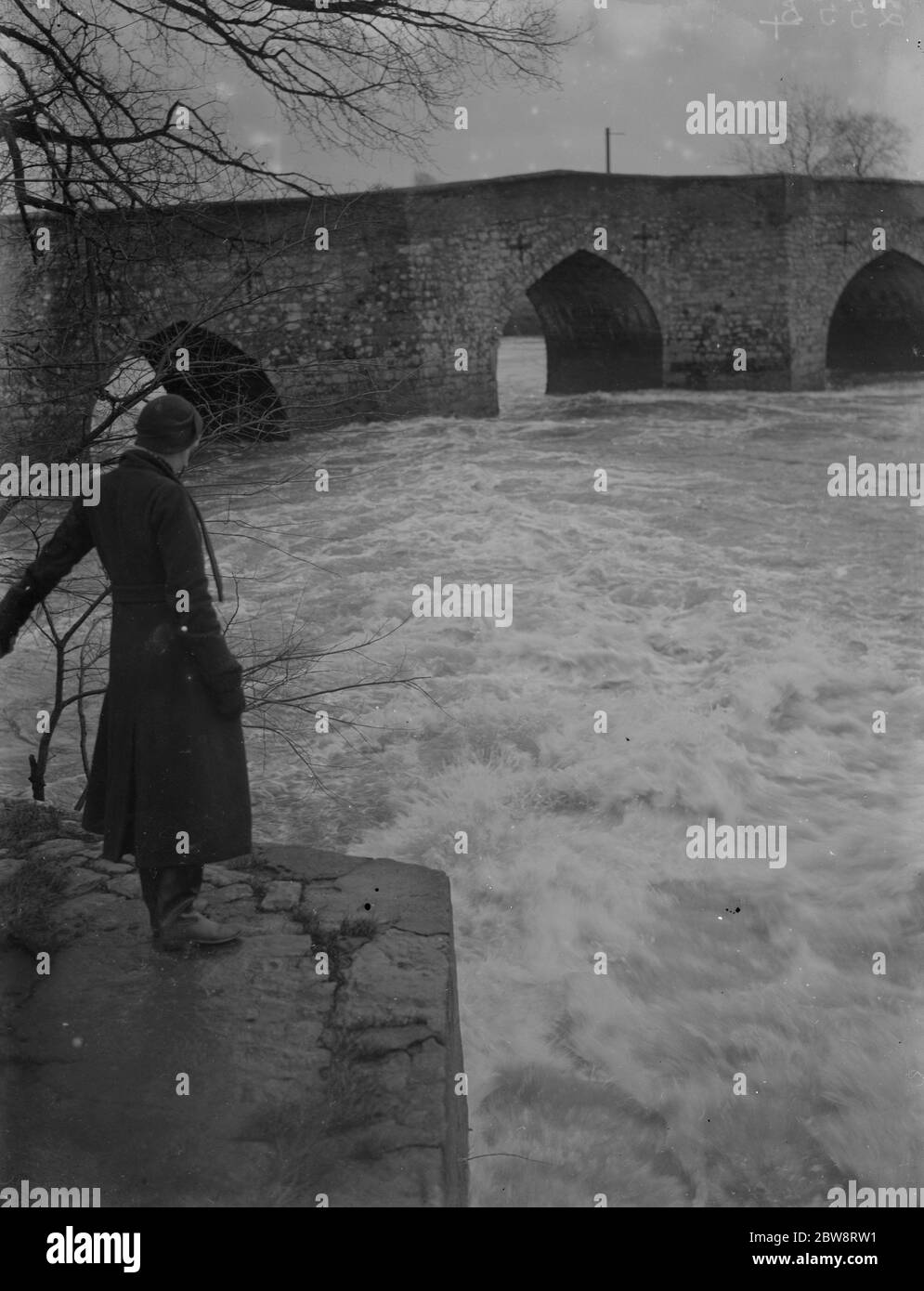 Ein voller, rauschender Fluss an der alten Steinbrücke in Yalding in Kent nach der Überschwemmung. 1935 Stockfoto
