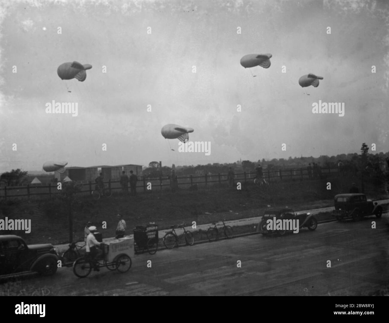 Air Minister Sir Kingsley Wood eröffnet die erste Barrage Ballon Squadron Website in Kidbrooke, London, wo Praxis Ballons wurden aus den Hangars gebracht. Zuschauer beobachten Praxis Ballons schweben aus ihren Kabeln. September 1938 Stockfoto