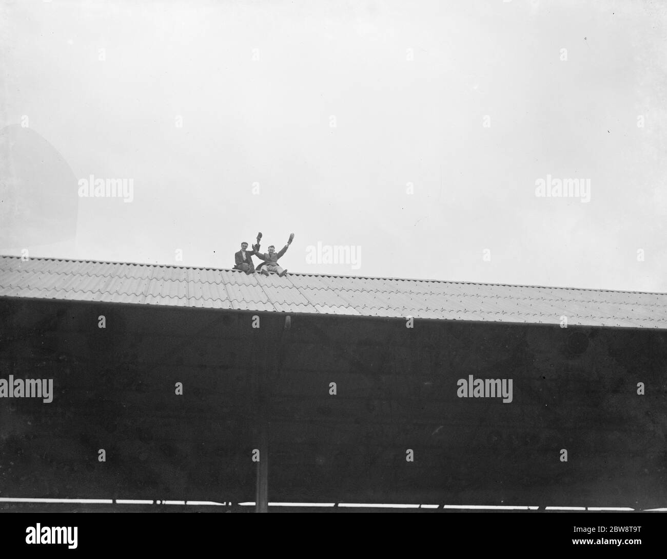 Fußballspiel: Arsenal Football Club gegen Charlton Athletic Football Club im Highbury Stadium, London. Zuschauer sitzen auf dem Dach des Ständers. 1936 Stockfoto