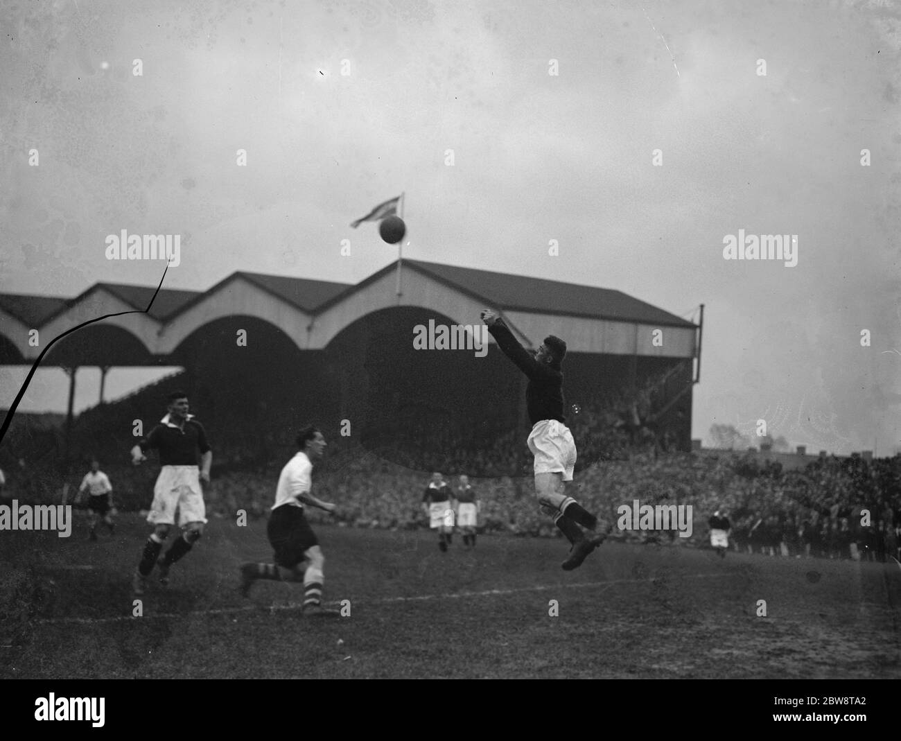 Fußballspiel: Arsenal Football Club gegen Charlton Athletic Football Club im Highbury Stadium, London. Torhüter schlägt den Ball weg. 1936 Stockfoto