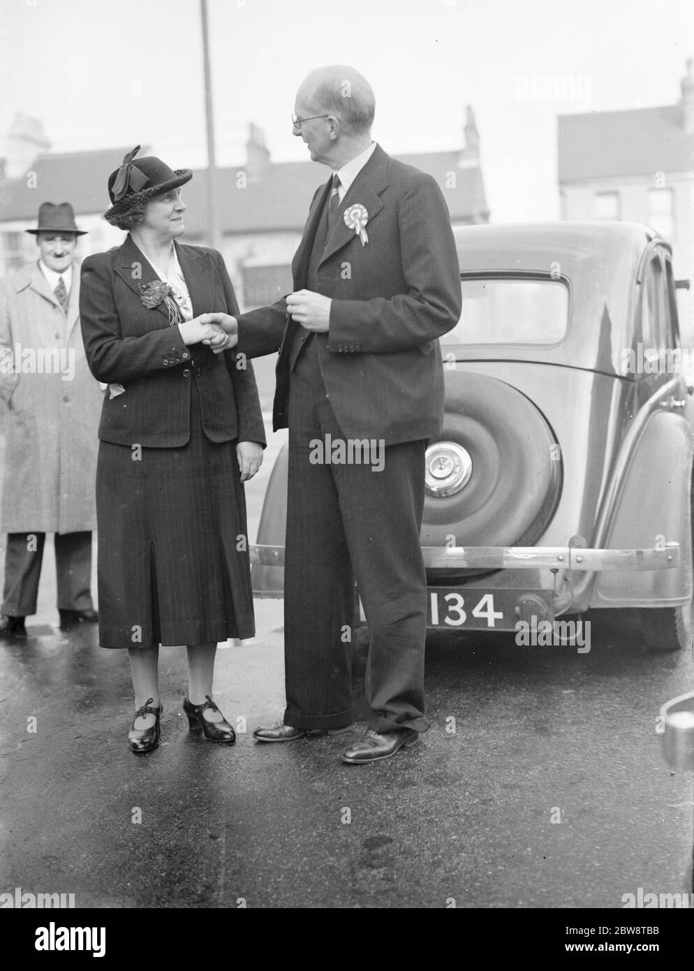 Herr Godfrey Mitchell, Konservativer (Kandidat der Nationalverwaltung) und Frau Janet Jennie Adamson, Kandidat der Labour Party, schütteln die Hände. Sie sind auf ihrem Wahlkampfweg für die Nachwahl in Dartford, Kent. 1938 Stockfoto