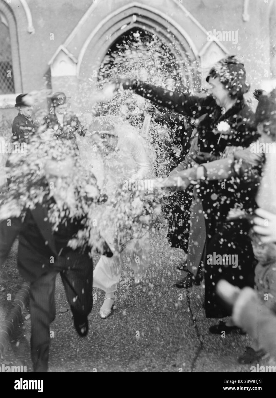 Die Hochzeit Kenwards und Martin. Die Braut und der Goom werden mit Konfetti übergossen, als sie die Kirche verlassen 1936 Stockfoto