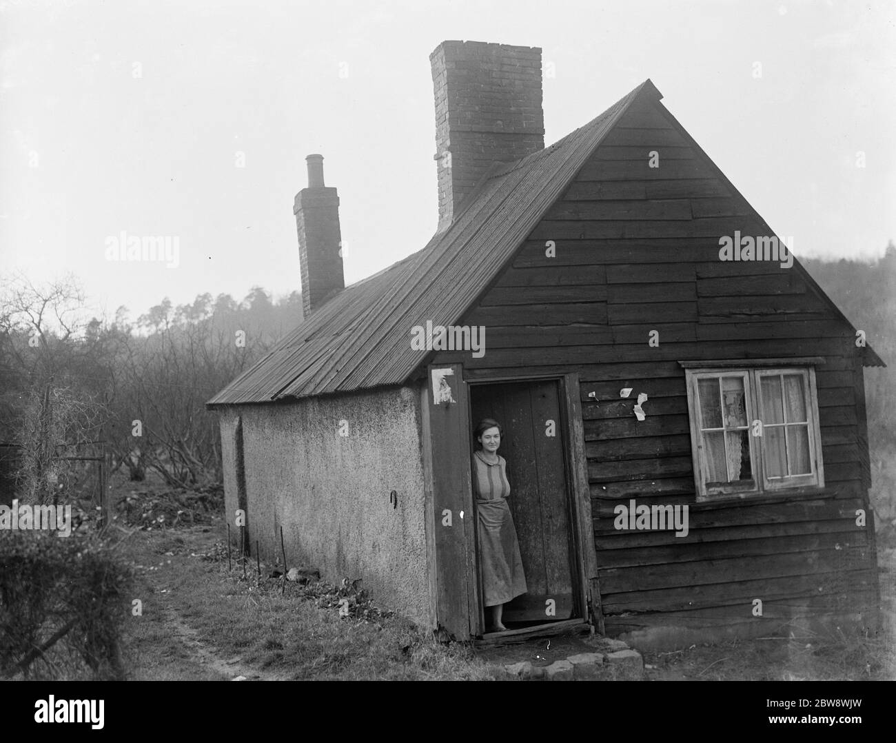 Eine Frau steht in der Tür eines Hauses, das einmal eine Leichenhalle war. 1937 Stockfoto