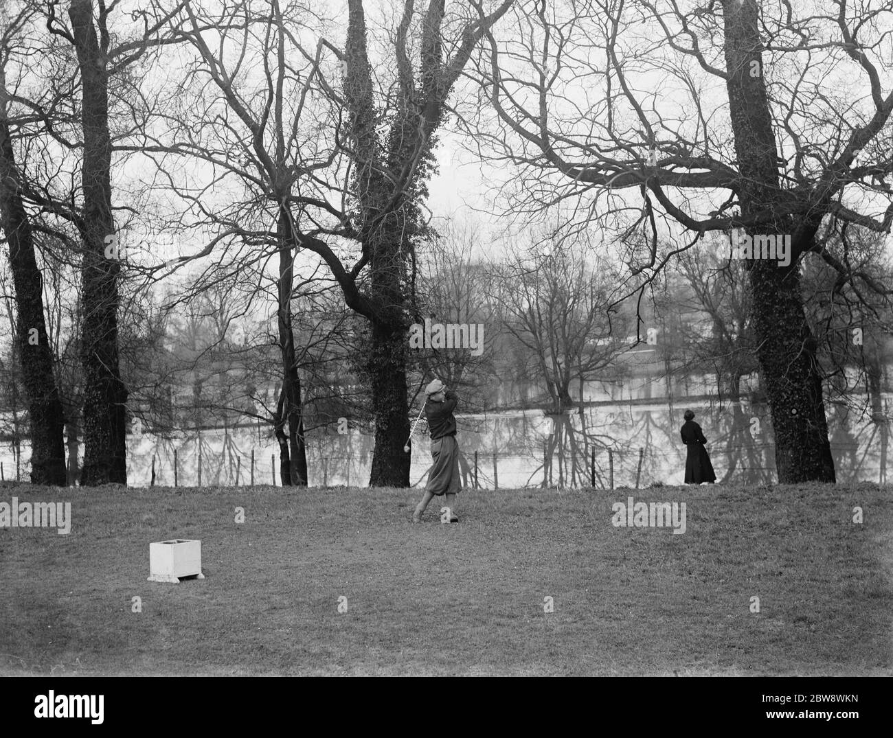 Das Dorf Horton Kirby, Kent, wo der Fluss Darent überflutet hat. Nichts kann diesen Golfer abschrecken. 1937 Stockfoto