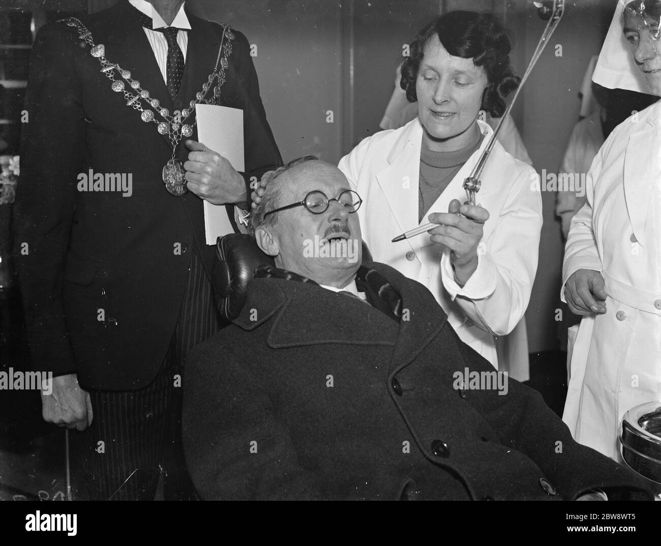 Lord Horder, der anerkannte Arzt, eröffnet eine Klinik in Woolwich, London. Hier nimmt er einen Platz im Zahnarztstuhl ein. 15. Januar 1939 Stockfoto