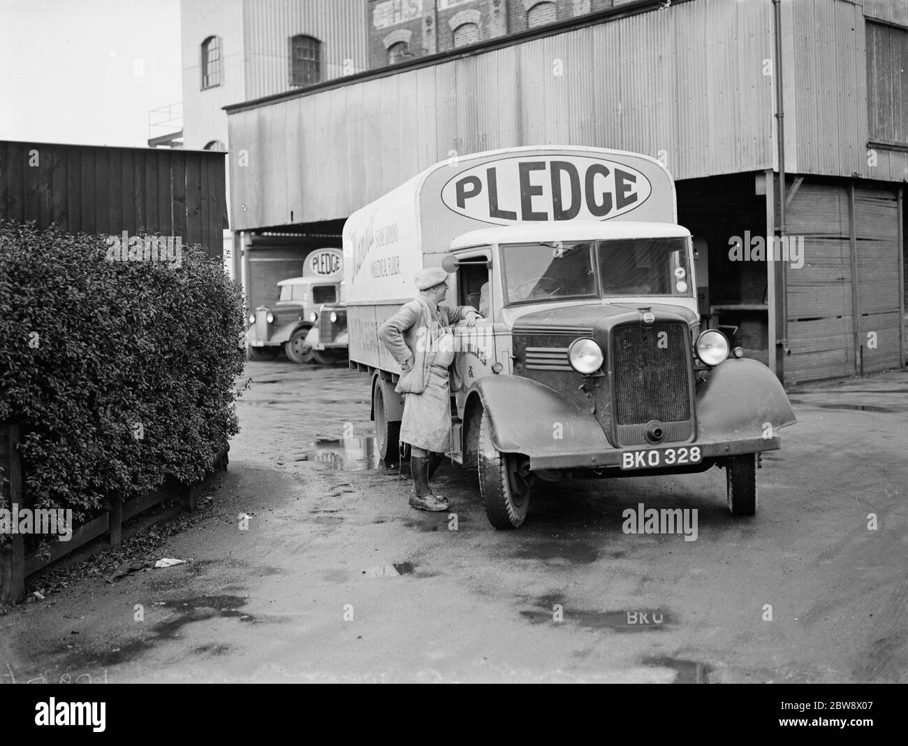 Ein Arbeiter plaudert mit dem Fahrer eines beladenen Bedford-Trucks, der zu Pledge & Son Ltd gehört, der Müllerei, während er ihre Victoria Mills in Ashford, Kent, herauszieht. 1939 Stockfoto