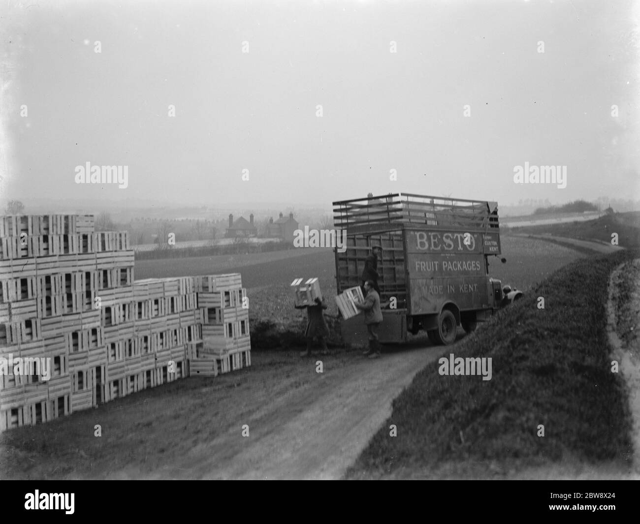 Entladen von Kisten aus einem LKW, der zu Besto gehört, dem Obstverpackungsunternehmen aus Kent. 1937 Stockfoto