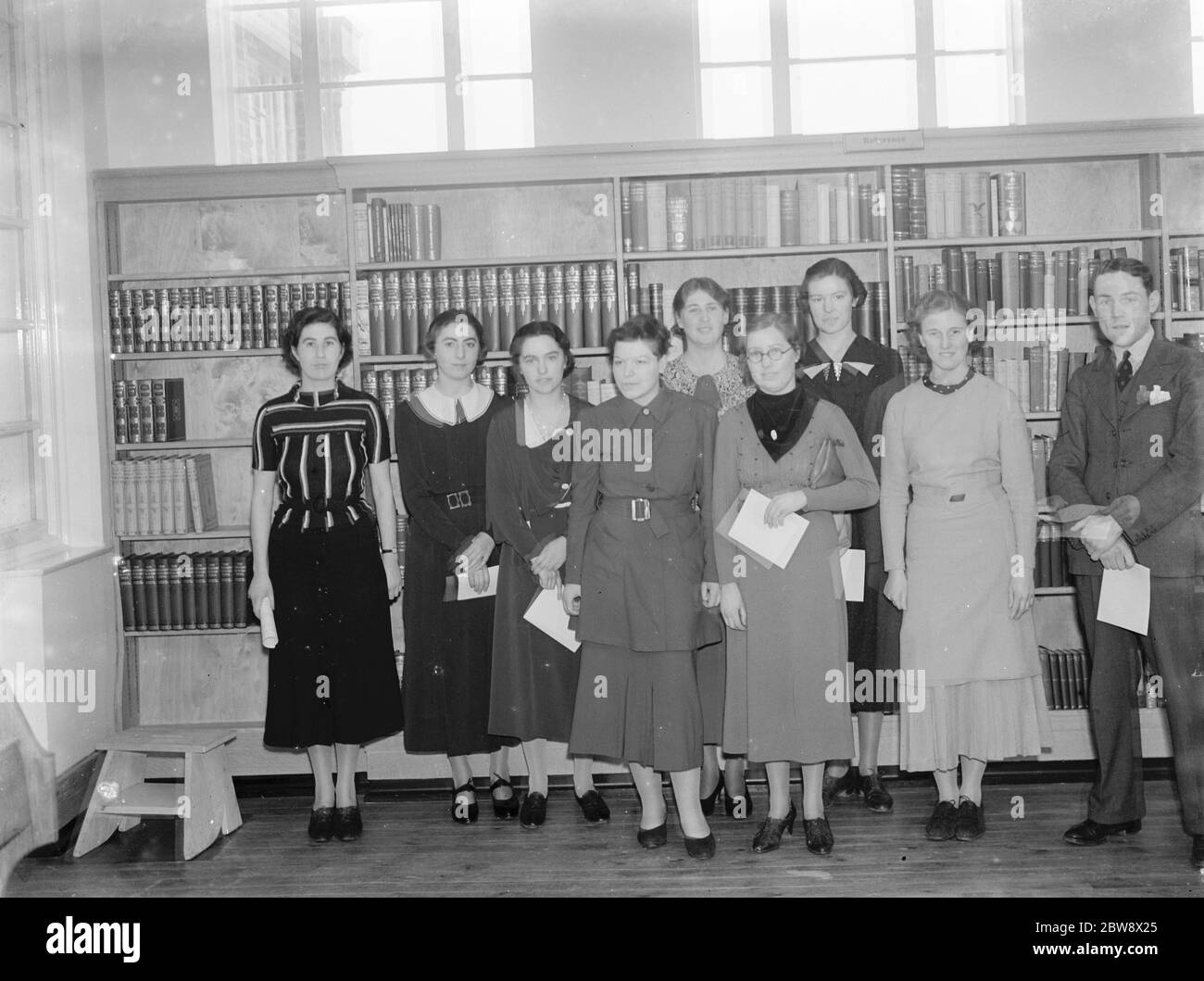 Ein Innenansicht der neuen Blackfen Library an der Cedar Avenue in Blackfen, London. Eine Gruppe posiert vor einem der Regale. 1937 Stockfoto