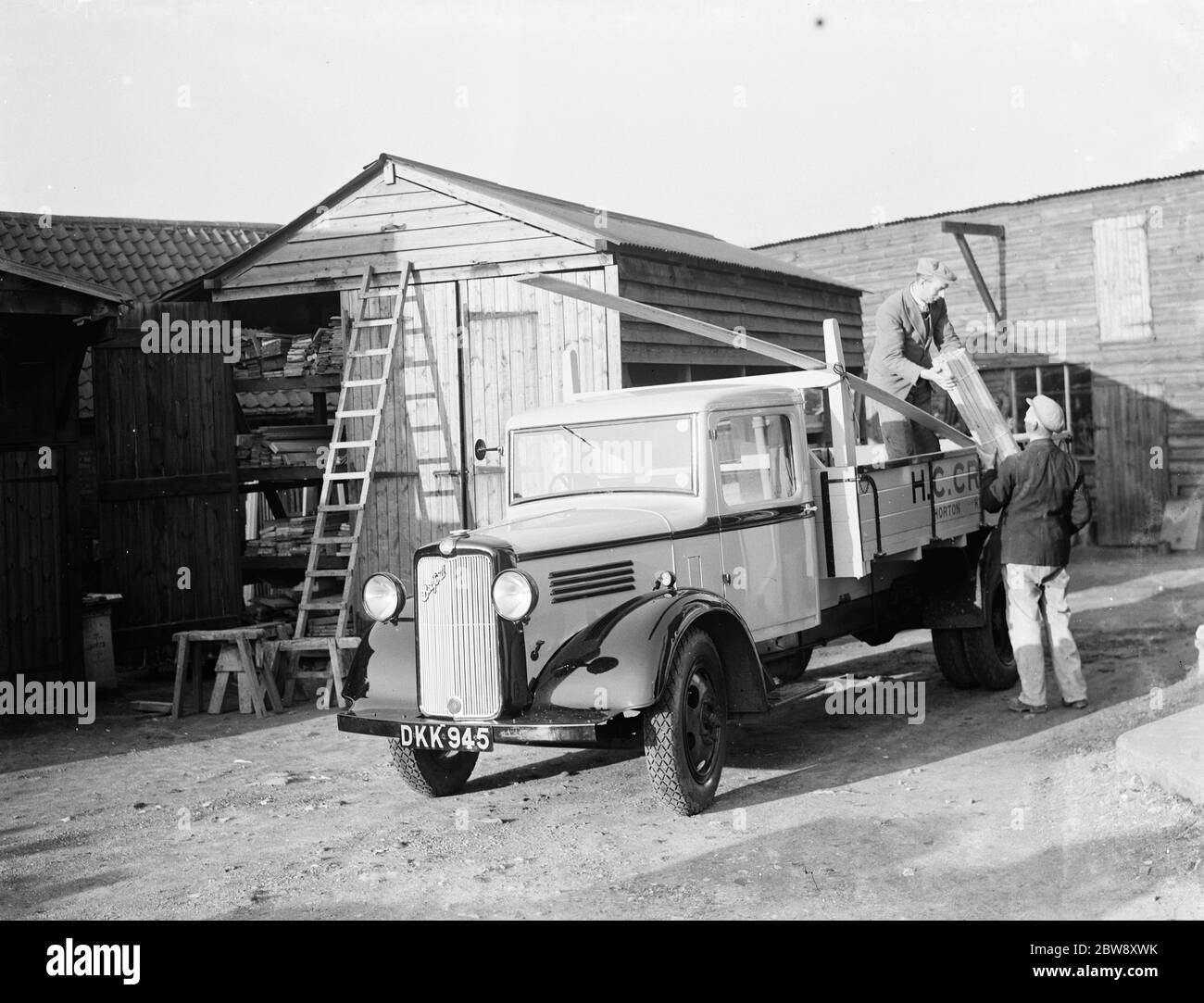 Ein Bedford LKW zu H C Crose von Horton Kirby, beladen mit Brettern aus Holz von zwei Arbeitern. 1937 Stockfoto