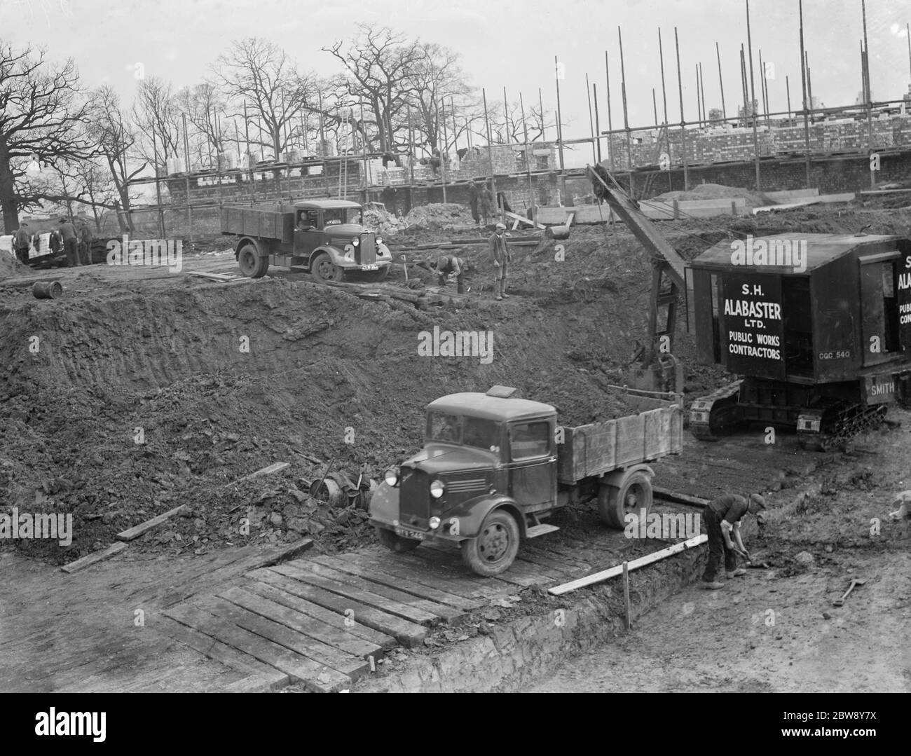 Bagger räumt das Land und setzt Erde in die Rückseite des Bedford LKW auf dem Gelände des neuen Bexleyheath Schwimmbad-Website in Bexleyheath , Kent . 1936 Stockfoto