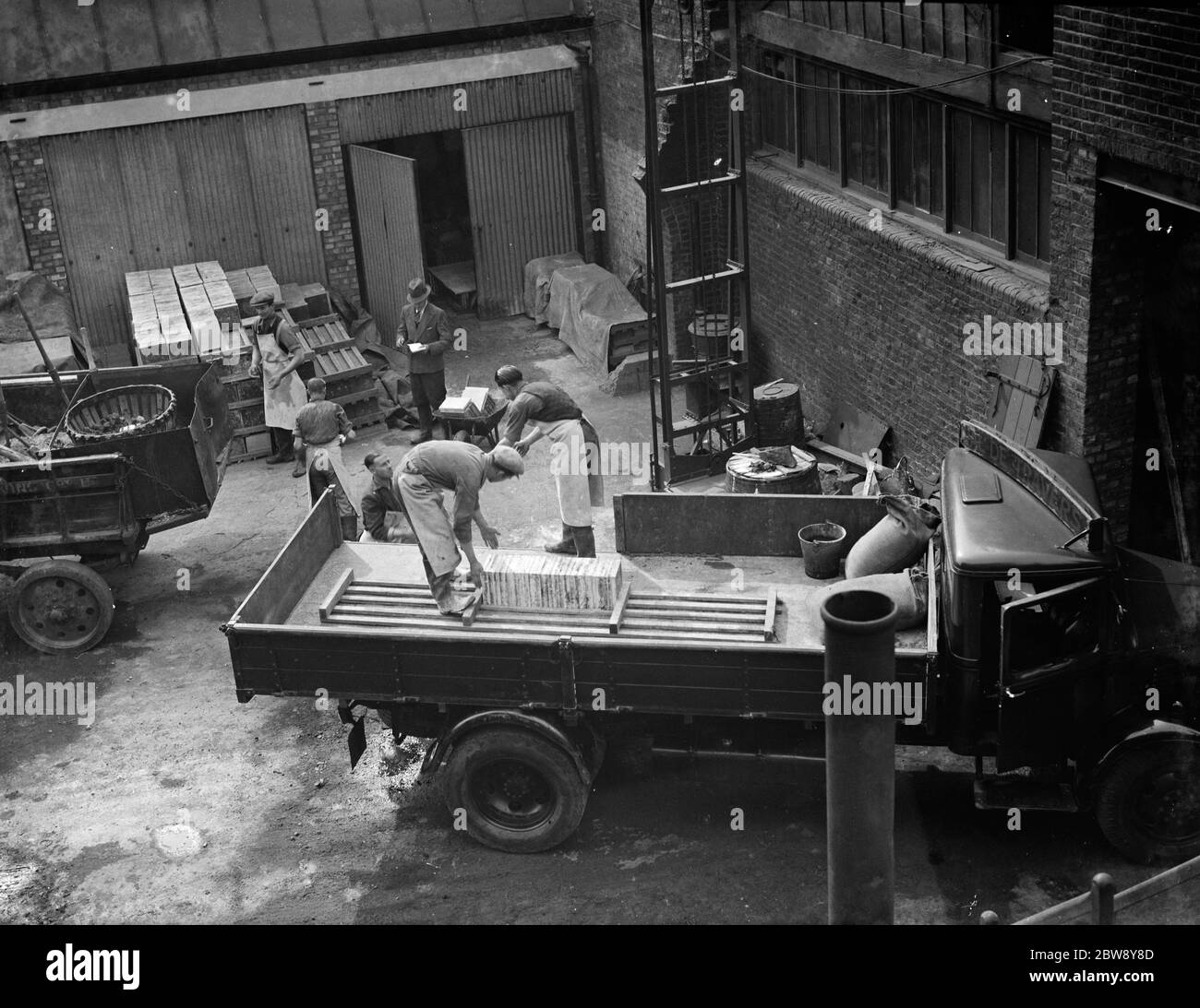 Arbeiter laden einen Bedford-LKW mit Fliesen. 1938 Stockfoto