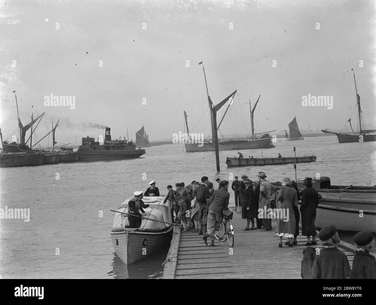 Die Heimatflotte auf der Themse in Greenhithe, Kent. Schulkinder besteigen ein Boot von einem schwimmenden Dock. 1937 Stockfoto