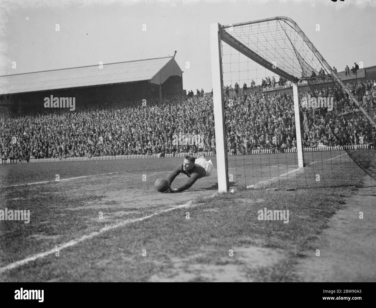 Fußballspiel : Erith und Belvedere gegen Dulwich Hamlet im London Senior Cup Finale . Tormündung Aktion - der Torwart taucht für den Ball. 1937 Stockfoto