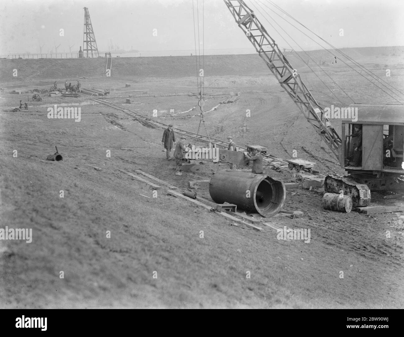 Arbeiter mit einem Kran für den Bau des Dartford Tunnels . Die Arbeiten beginnen am Eingang. 1937 Stockfoto