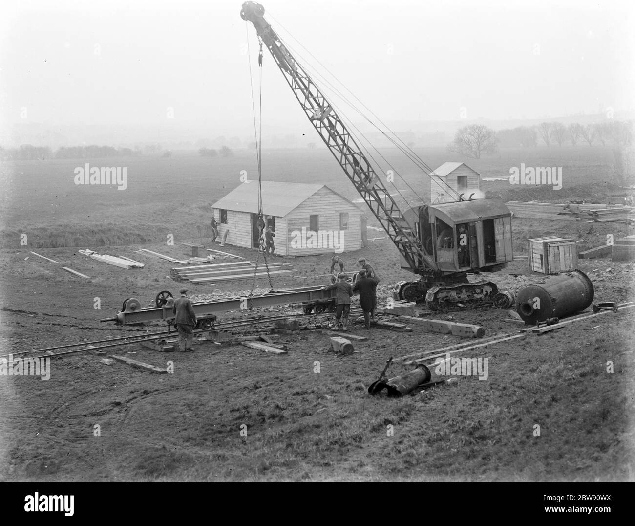 Arbeiter mit einem Kran für den Bau des Dartford Tunnels . Die Arbeiten beginnen am Eingang. 1937 Stockfoto