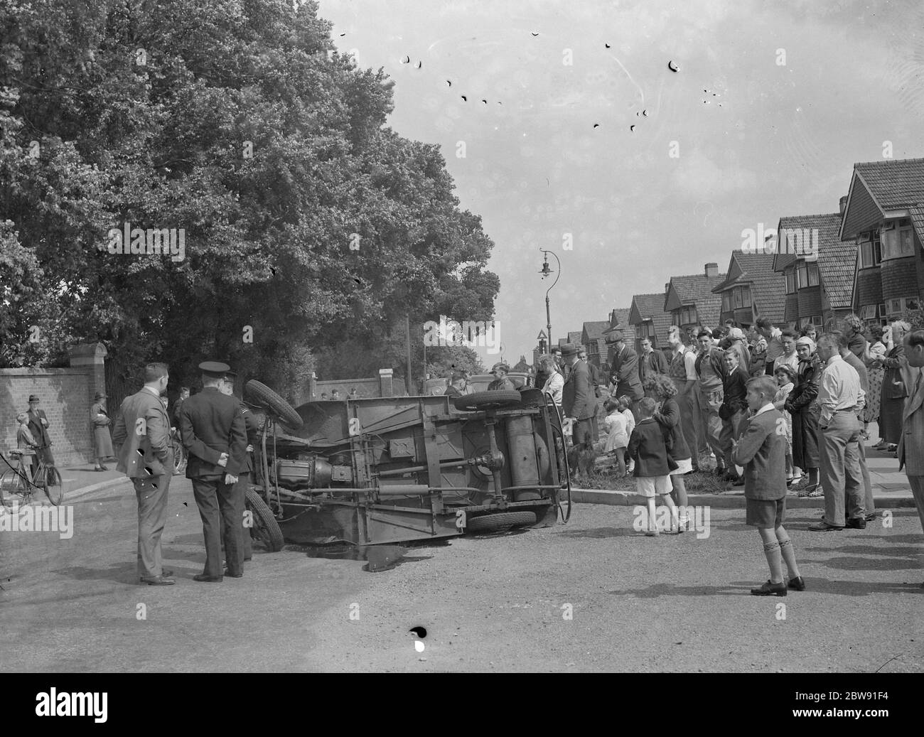 Eine Menge versammelt sich um ein abgestürztes Auto auf der Halfway Street in Sidcup, Kent. 1939 Stockfoto