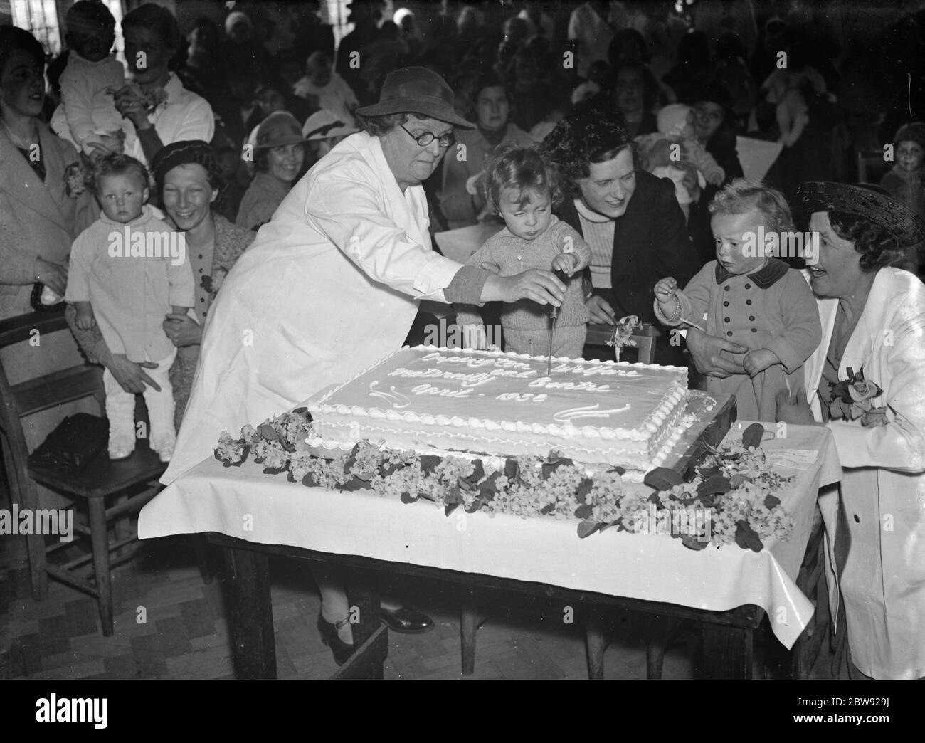 Schneiden Sie den Kuchen im Orpington Wohlfahrtszentrum . 1938 Stockfoto