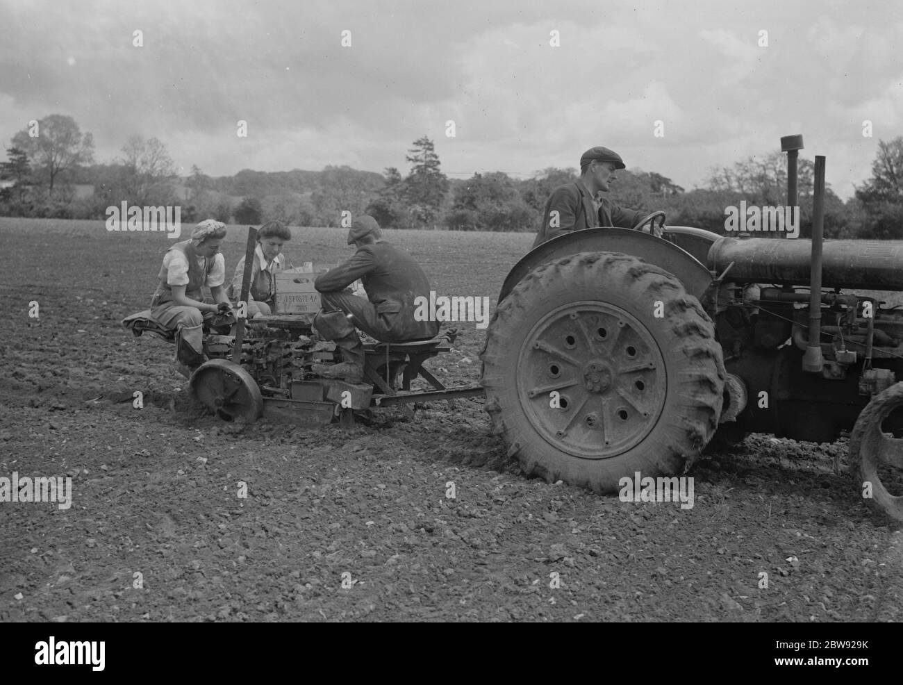 Landarbeiter mit einem Tracter gezeichnet Transplantatoren Robot Ltd Pflanzmaschine . 1939 Stockfoto