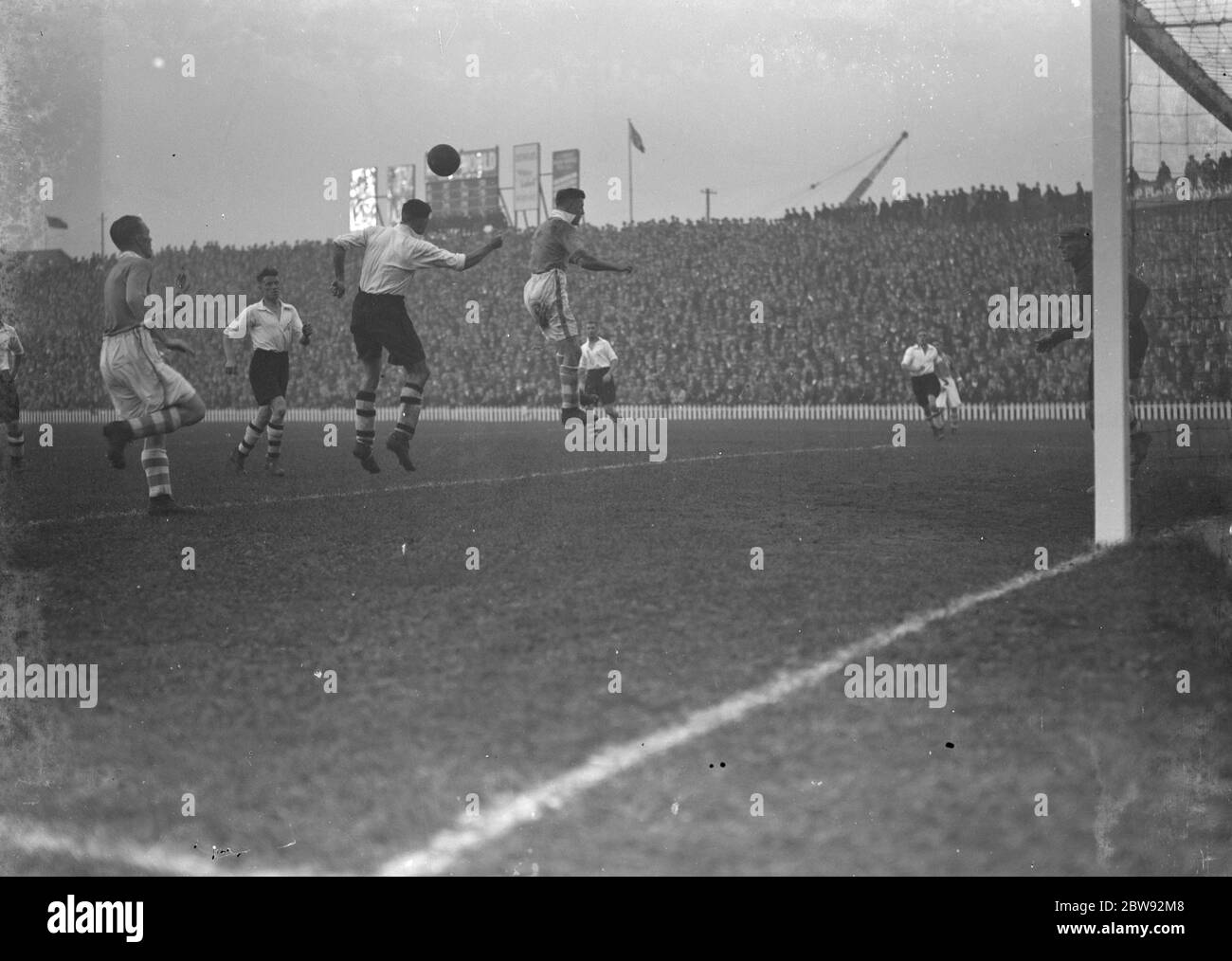 Action auf dem Fußballplatz . Ein Spieler geht für einen Header . 1939 Stockfoto