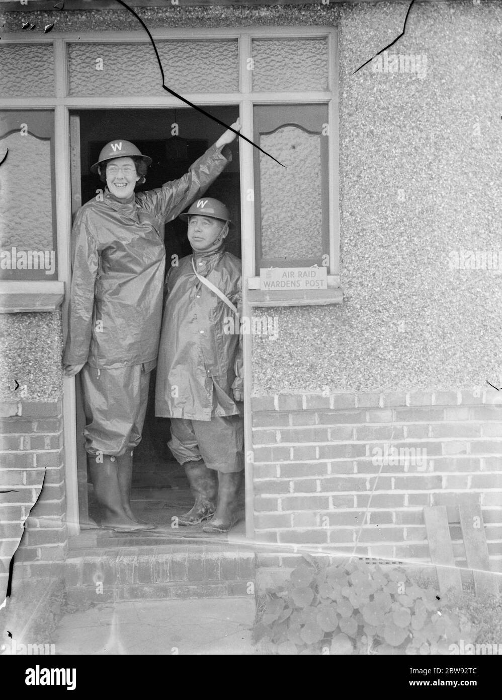 Die höchste Frau Luftangriffswarden, Miss B Allnutt, posiert in einer Tür mit Kollegen Warden, Herr G A Boys. Sie steht bei 6ft 2ins . 1939 Stockfoto