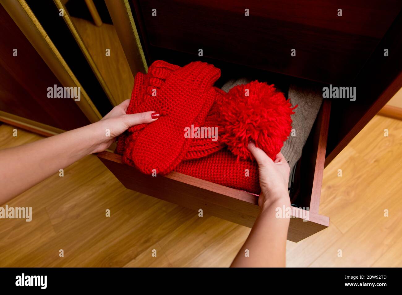 Mädchen nimmt eine Reihe von warmen Winter-Accessoires aus einer Box, Nahaufnahme Stockfoto