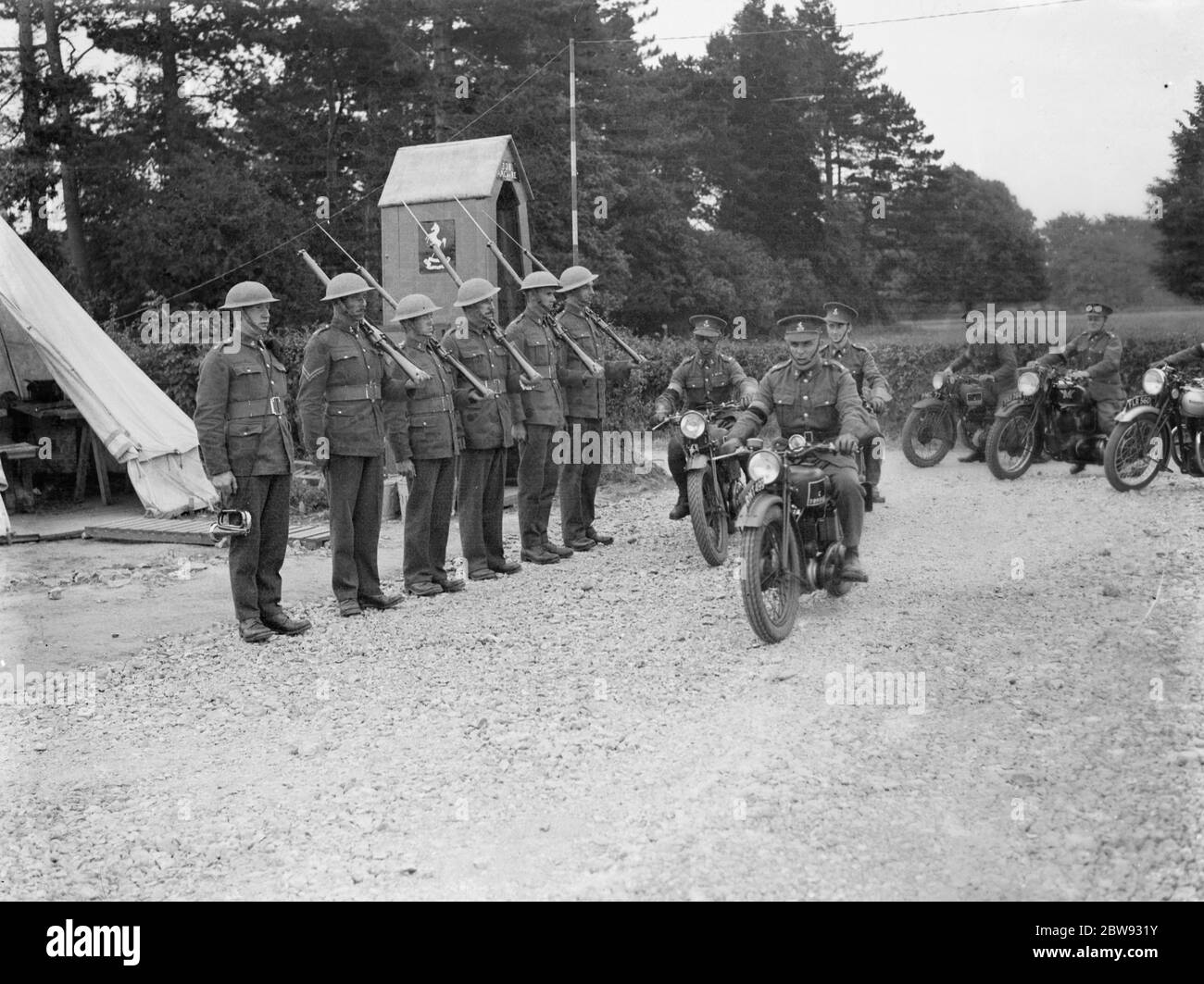 Territoriale Armee rekrutiert im Lager in Chichester, Sussex. Motorradfahrer fahren vorbei an Soldaten auf Wache. 1939 Stockfoto