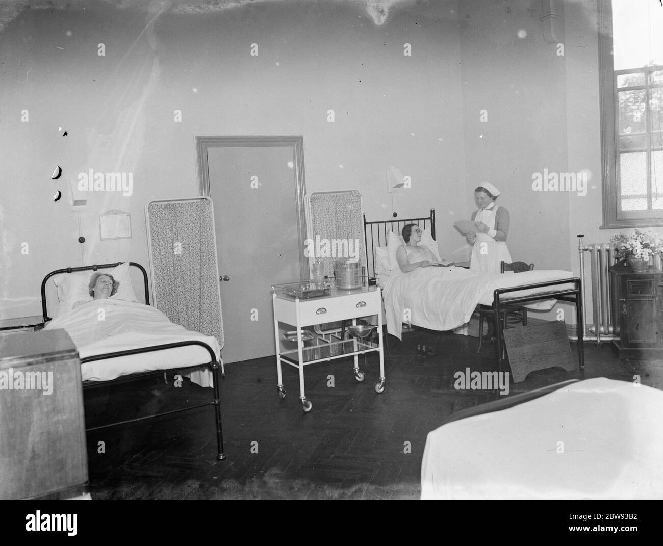 Das Sidcup Cottage Hospital in Kent. Eine Krankenschwester neigt zu einem Patienten in der Frauenabteilung. 1939 Stockfoto