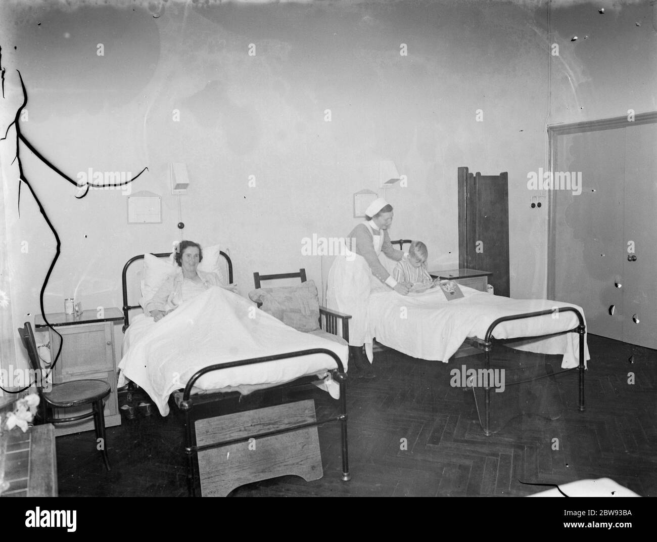 Das Sidcup Cottage Hospital in Kent. Eine Krankenschwester neigt zu einem Patienten in der Frauenabteilung. 1939 Stockfoto