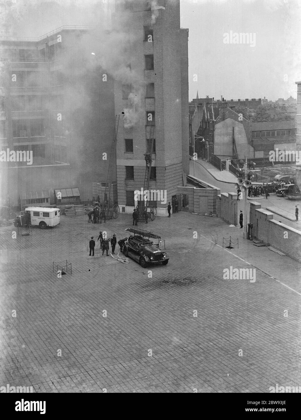 Eine Ausstellung der Londoner Feuerwehr in Lambeth, London. Feuerwehrleute verwenden Verlängerung Leitern, um ein hohes Gebäude während der Demonstration zu steigen. 1939 Stockfoto