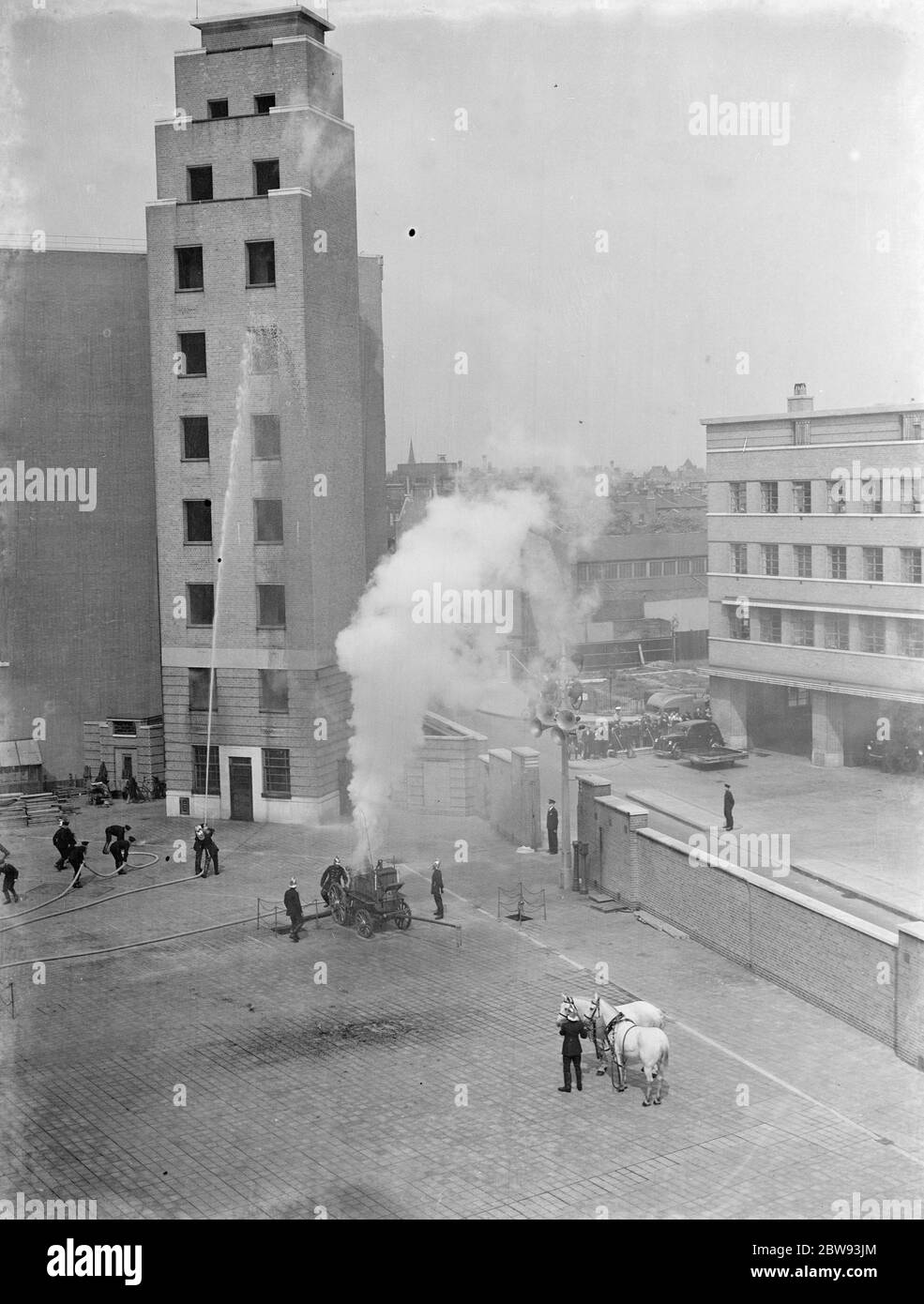 Eine Ausstellung der Londoner Feuerwehr in Lambeth, London. Die Feuerwehr pumpt während der Demonstration Wasser mit einer dampfbetriebenen Feuerwehrmaschine in das 7. Geschoss eines hohen Gebäudes. 1939 Stockfoto