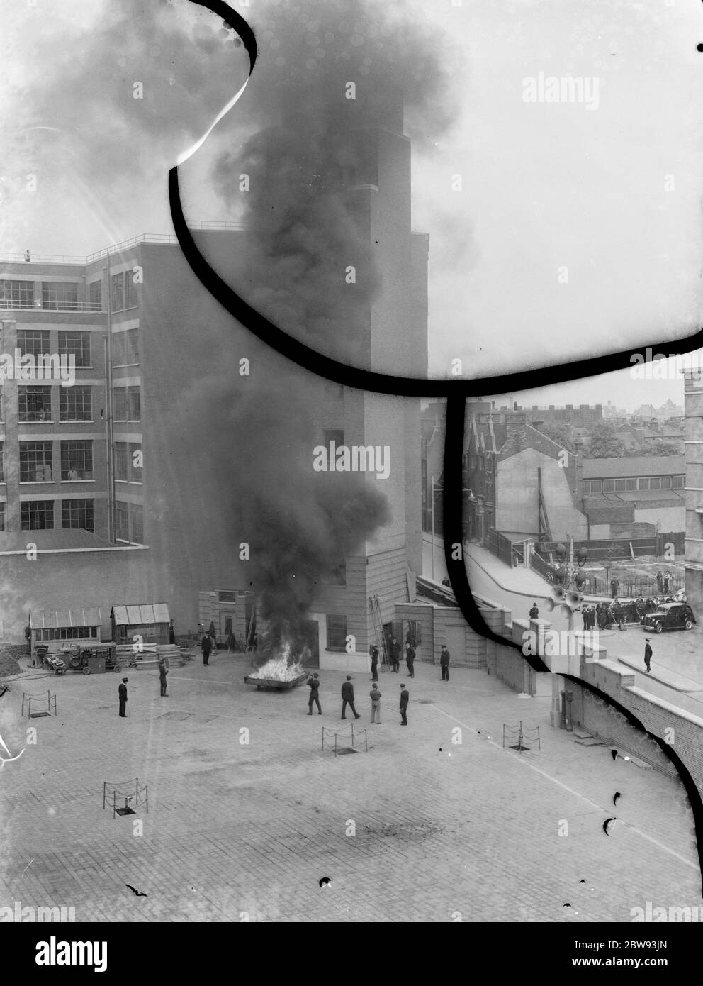 Eine Londoner Feuerwehr-Display in Lambeth, London. Die Feuerwehr reagiert während der Demonstration auf einen Brand am Fuße eines Hochhauses. 1939 Stockfoto