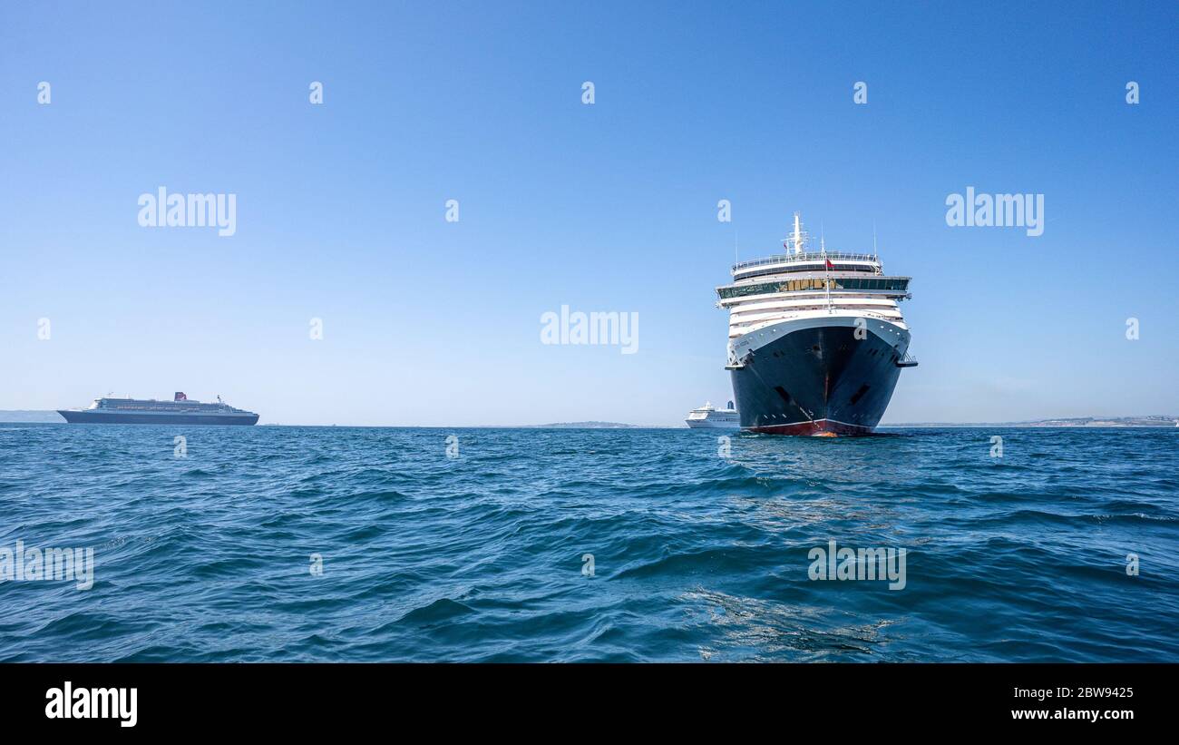 WEYMOUTH BAY, WEYMOUTH, DORSIT, GROSSBRITANNIEN. Mai 2020. Das Cunard RMS Queen Victoria Kreuzfahrtschiff (rechts) sucht Zuflucht in Weymouth Bay, Dorset, mit dem Queen Mary 2 Kreuzfahrtschiff des Unternehmens im Hintergrund (links) während des COVID-19 Pandemic Outbreak. Foto von David Horn. Kredit: Prime Media Images/Alamy Live News Stockfoto