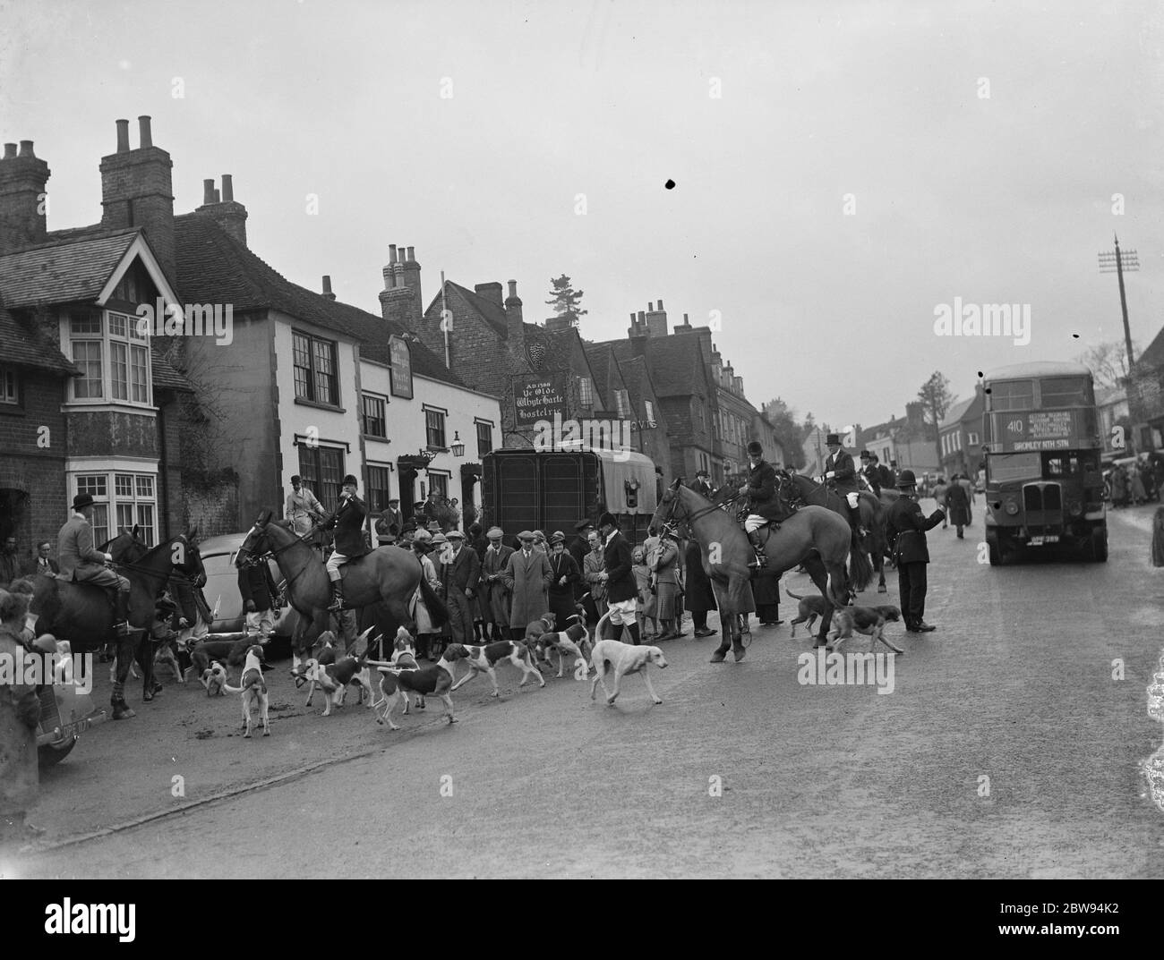 Jagdszenen in Bletchingley, Surrey. Die Hunde laufen vor den Jägern durch die Straßen. 1936 Stockfoto