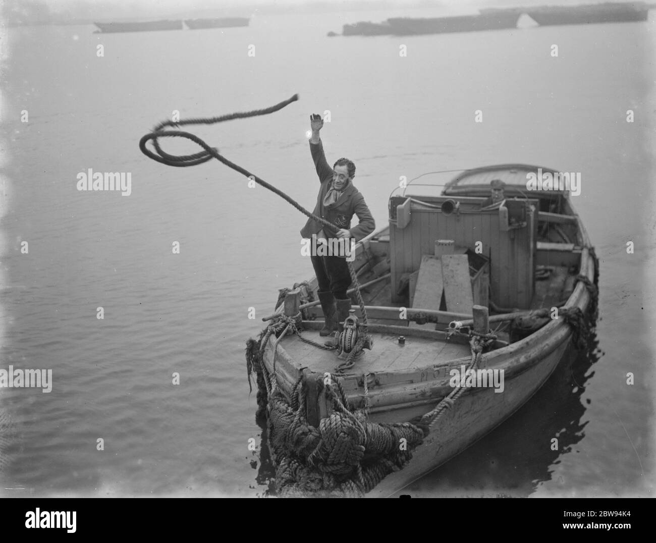 Herr Frank Clark MP wirft die Linien auf die Kai Seite, um das Boot zu binden. 1936 Stockfoto