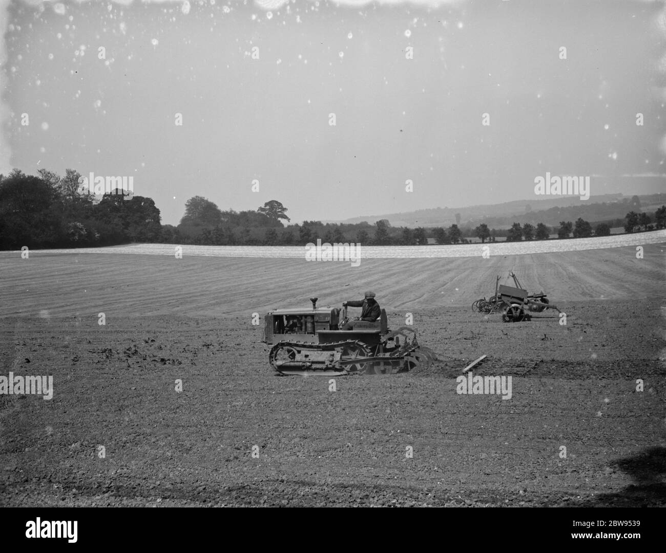 Ein Bauer und seine Panzergleisentraktor, Egge ein Feld 1936. Stockfoto